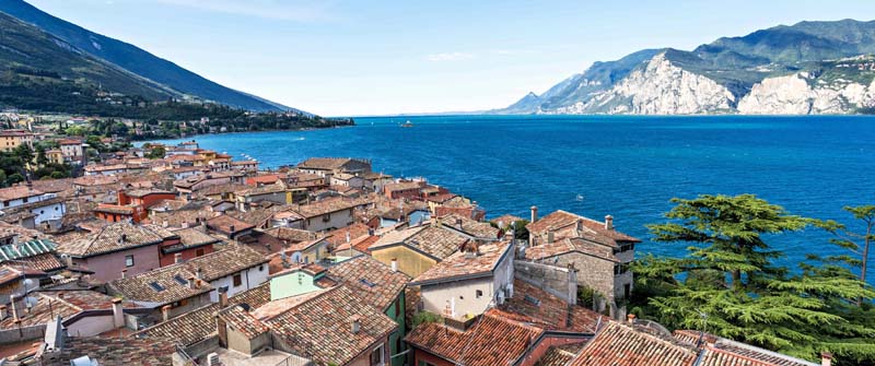 Blick über alte Dächer auf den Gardasee