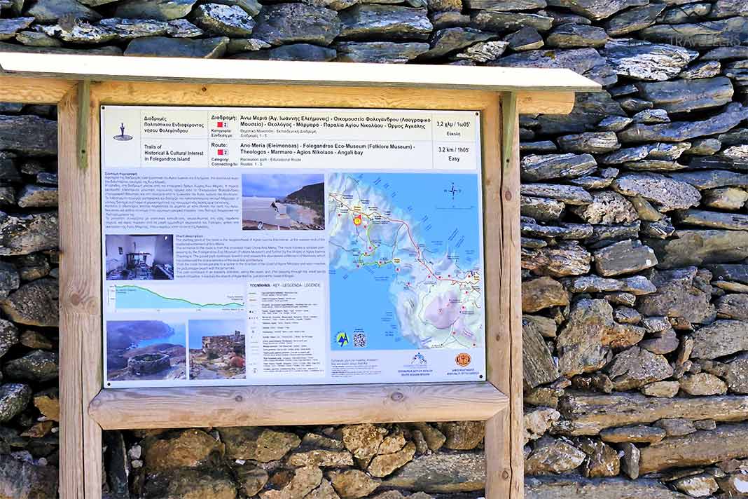 Wandertafel mit Erläuterungen vor einer Natursteinmauer