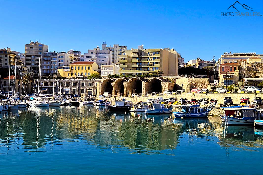 Kleine Boote ankern im Hafen von Heraklion mit mehrstöckigen Häusern im Hintergrund