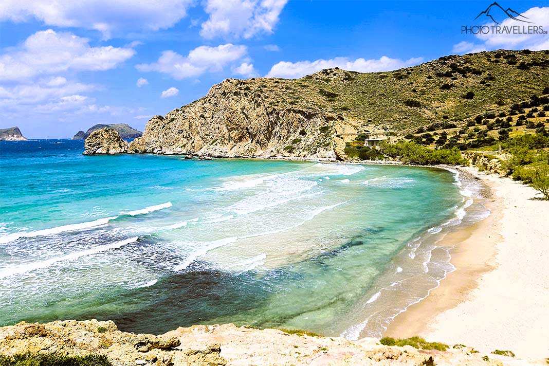 Wellen in türkistönen rollen auf den Sandstrand von Plathiena zu umrahmt von grünen Hügeln