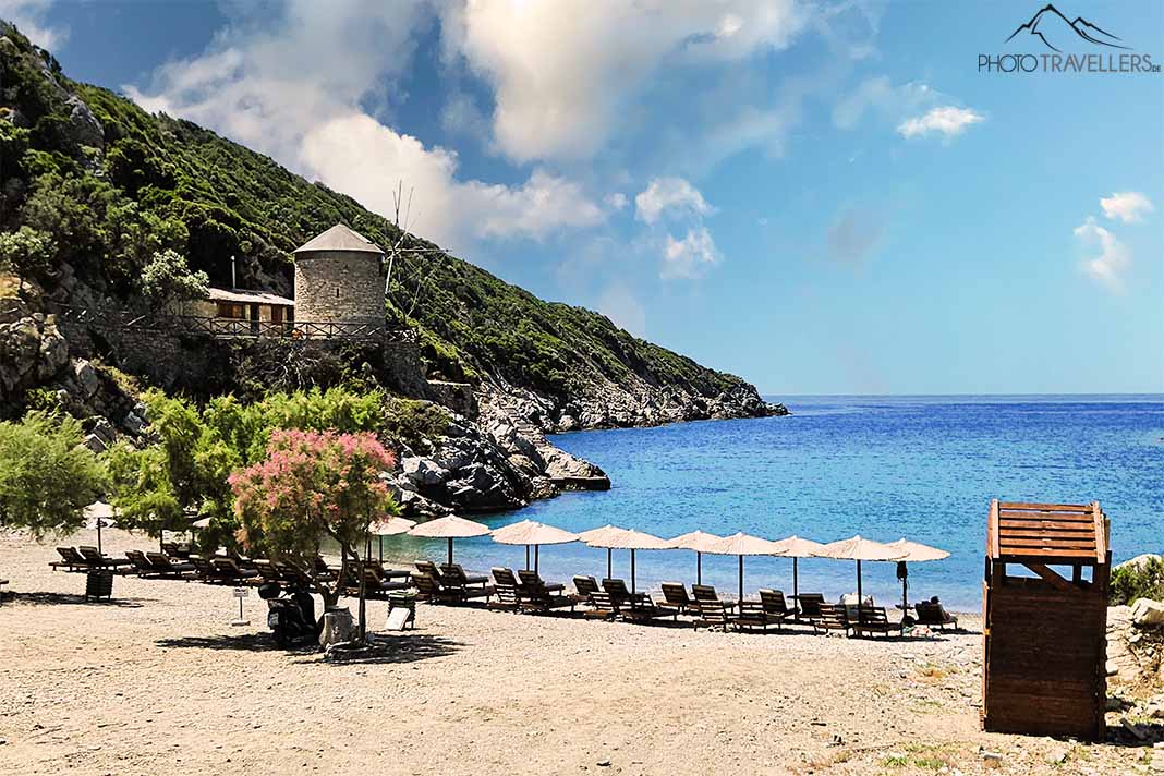 Eine alte Mühle und Liegestühle am Giala Beach auf Alonnisos