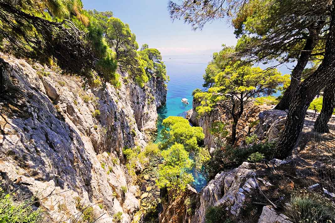 Schmale türkisfarbende Bucht zwischen mit Pinien bewachsenen Steilfelsen am Amarandos Cove