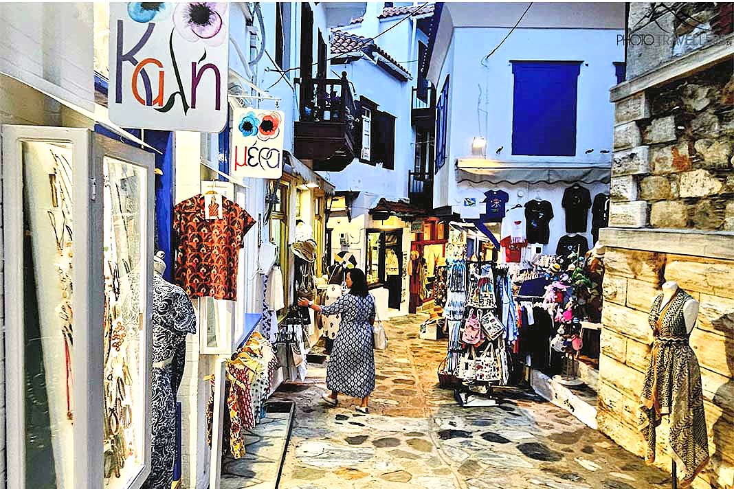 Frau zwischen beleuchteten Läden in den engen Gassen der Altstadt von Skopelos