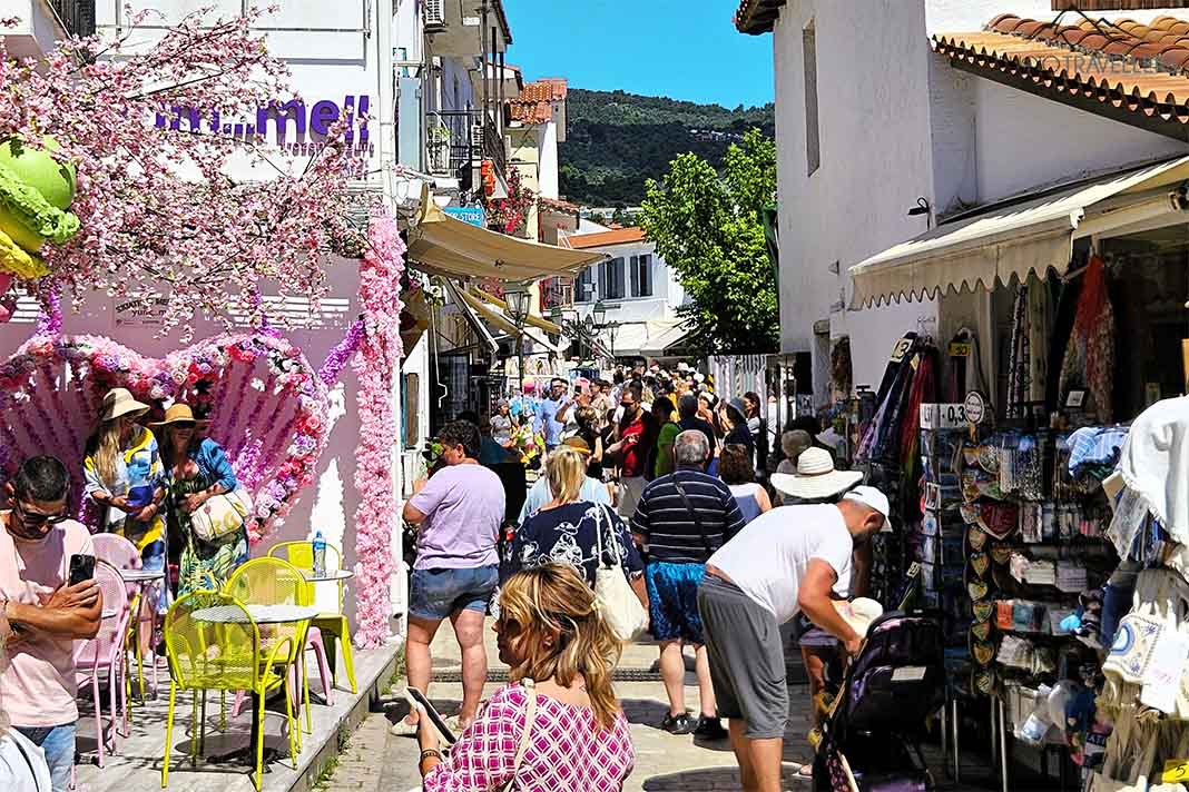 Viele Menschen laufen durch eine enge Ladengasse in Skiathos-Stadt