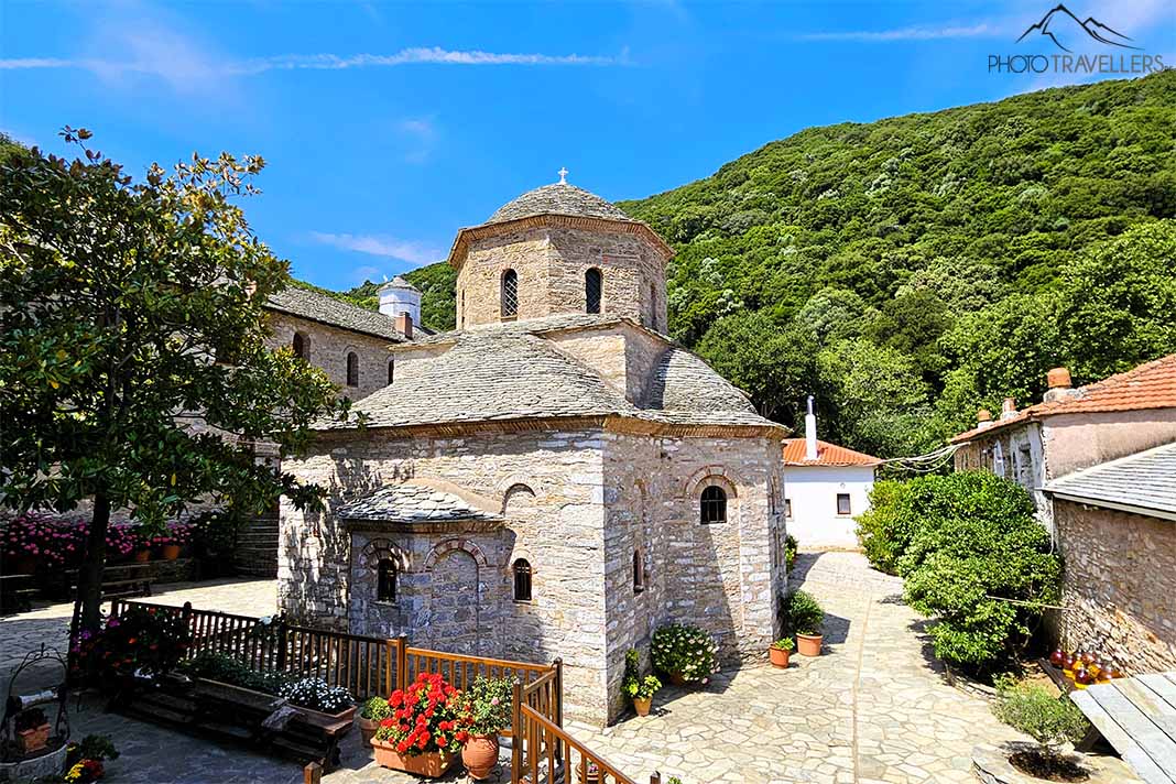 Blick auf das Kloster Moni Evaggelismou mit grünen Hügeln im Hintergrund