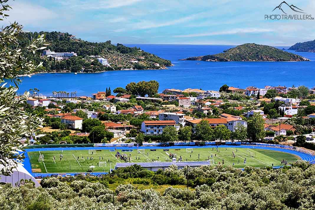 Blick von oben auf Skiathos-Stadt am Meer mit dem Fußballplatz im Fokus