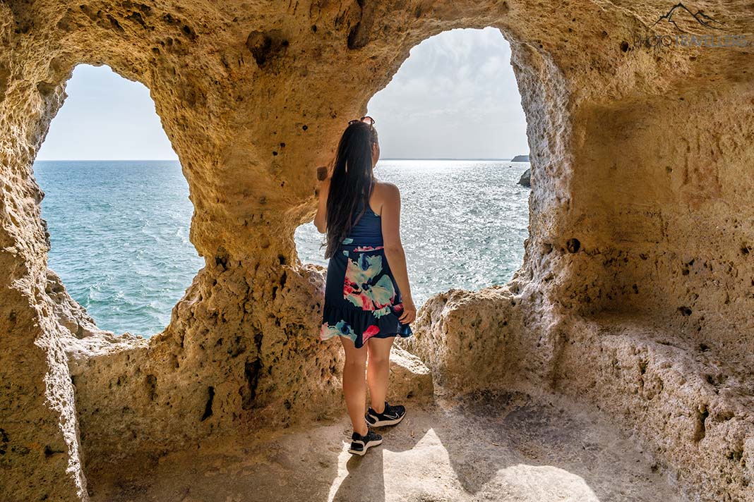 Reisebloggerin Biggi Bauer blickt aus einem Felsenfenster aufs Meer
