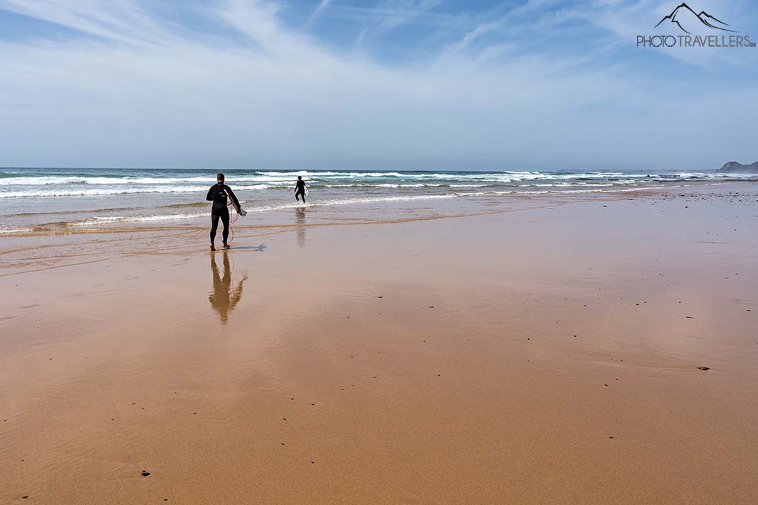 Zwei Surfer am Strand Praia da Cordoama