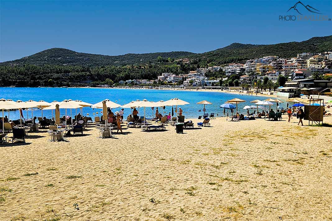 Rapsani-Beach bei Kavala mit Badegästen unter Sonnenschirmen am Sandstrand