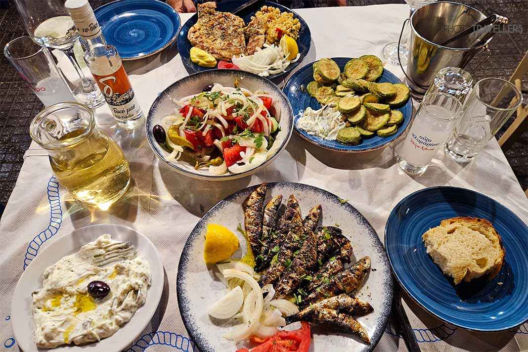 Verschiedene Teller mit griechischen Speisen wie Tzatziki, Sardinen und Zucchini