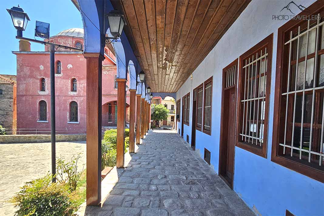 Überdachter Laubengang der Schule vor der rosa Fassade der Halil Bey-Moschee