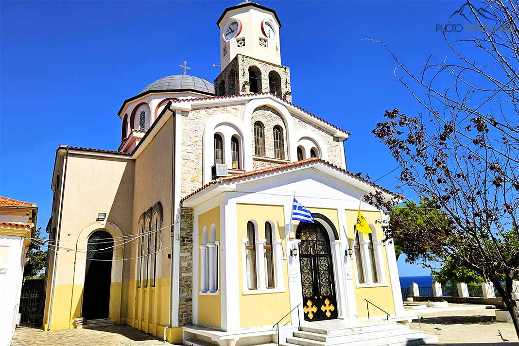 Mehrreihiges Ensemble der Kirche Kimisi di Theotokou mit Glockenturm und gelber Fassade