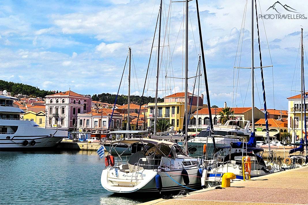 Segelboote mit hohen Masten ankern vor den historischen Häusern an der Promenade von Mytilini