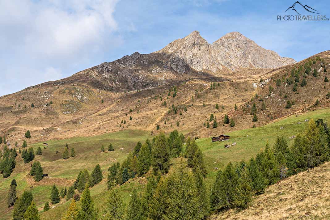 Blick auf Almhütten und schroffe Gipfel